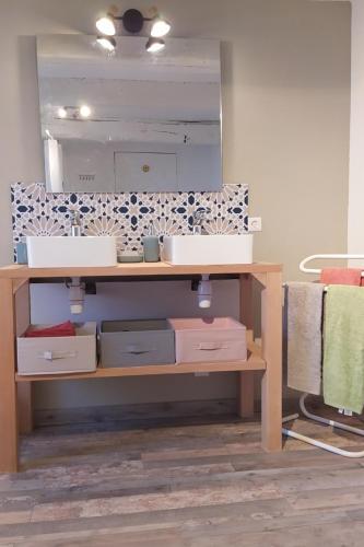 une salle de bain avec un lavabo et un miroir dans l'établissement Maison Kalisol, à Pleine-Fougères