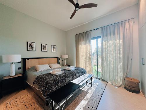 une chambre avec un lit et un ventilateur de plafond dans l'établissement Villa du golf, à Sainte-Maxime