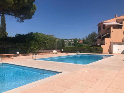 - une piscine à côté d'un bâtiment dans l'établissement Les terrasse de la mer, aux Issambres