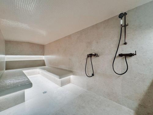 La salle de bains est pourvue d'une douche et d'un banc. dans l'établissement Villa du golf, à Sainte-Maxime