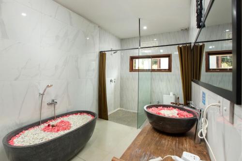 a bathroom with two large tubs and a shower at Tamyang Ubud Villas in Ubud