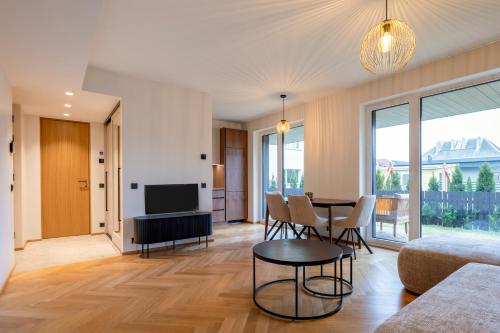 a living room with a table and chairs and a television at Heven Apartments Karusselli in Pärnu