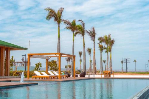 a pool with chairs and palm trees and a gazebo at Karibao Ecuabook Room Jacuzzi Sea View 7B in Playas
