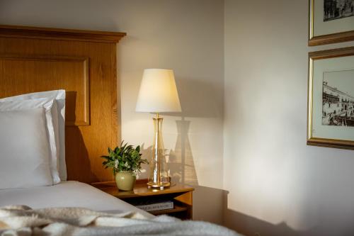a bedroom with a bed and a lamp on a table at Corinthia Palace Malta in Attard