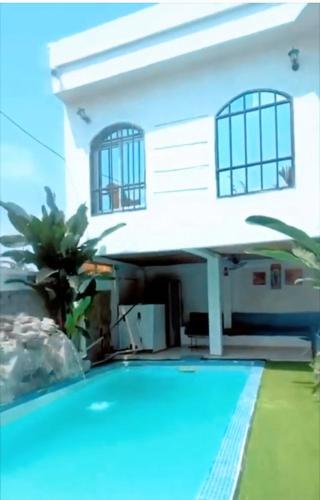 a house with a swimming pool in front of a house at Villa Saint-Sulpice Apt avec piscine in Yaoundé