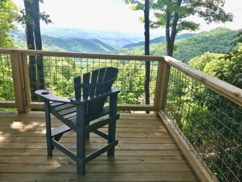a blue chair sitting on a wooden deck with a view at Unique Rustic Barn Theme home Amazing views! Luxe in Bailey Camp