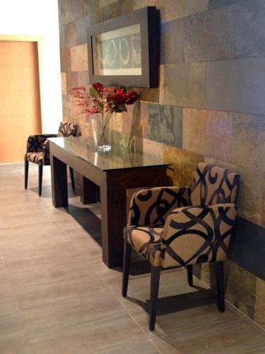 a table with two chairs and a vase with flowers at Hotel Macami in El Carpio