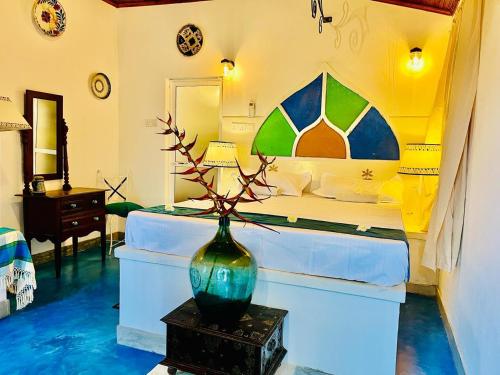 a bedroom with a bed and a vase on a table at The Nonnas Privacy Villa in Beruwala