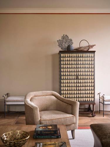 a living room with a chair and a table at Collegio alla Querce, Auberge Collection in Florence