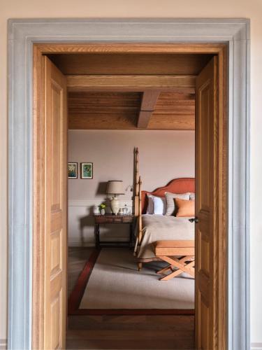 an open door into a bedroom with a bed at Collegio alla Querce, Auberge Collection in Florence