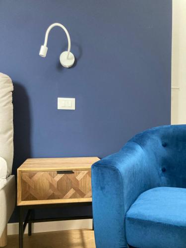 a living room with a blue chair and a table at Casa di Mirea in Grado
