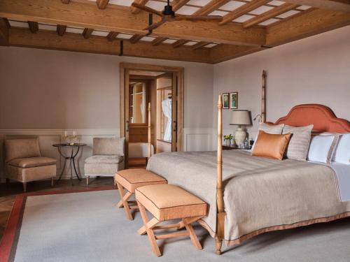 a bedroom with a large bed and a chair at Collegio alla Querce, Auberge Collection in Florence