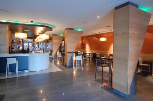 a restaurant with a bar and tables and chairs at Hotel Macami in El Carpio