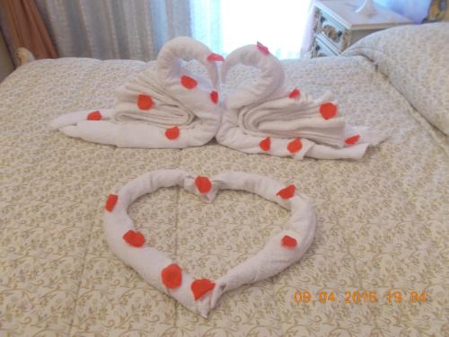 a pair of towels in the shape of a heart on a bed at Appartamento I Cedri in San Cesareo
