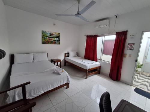 a bedroom with a bed and a couch and a window at Heliconias Hotel in Leticia