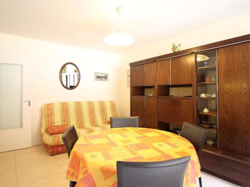 une salle à manger avec une table, des chaises et une armoire dans l'établissement T2 avec balcon, parking privé, proche forêt, Mont-Dore - FR-1-608-212, à Le Mont-Dore