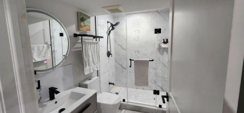 a white bathroom with a shower and a sink at Entire 2 Bedroom Apartment in Kitchener in Kitchener