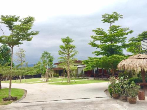 a house with trees and plants in front of it at บ้านไร่แสงเดือน รีสอร์ท in Ban Kha