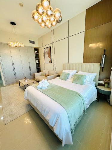 a bedroom with a large white bed and a chandelier at Lake City Tower in Dubai