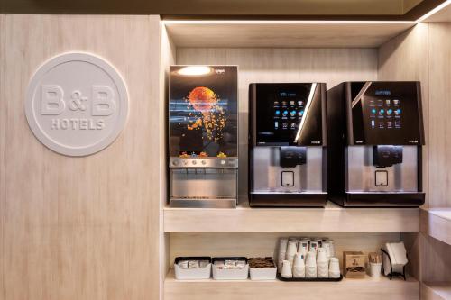a coffee shop with two microwaves on a wall at B&B HOTEL Santo Tirso in Santo Tirso