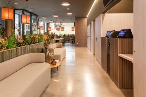 a lobby of a hospital with couches and plants at B&B HOTEL Santo Tirso in Santo Tirso