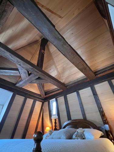 un lit dans une chambre avec un plafond en bois dans l'établissement Gîte le Romantique, à Colmar