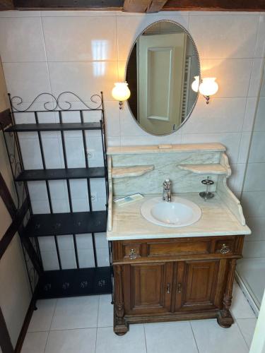 une salle de bain avec un lavabo et un miroir dans l'établissement Gîte le Romantique, à Colmar