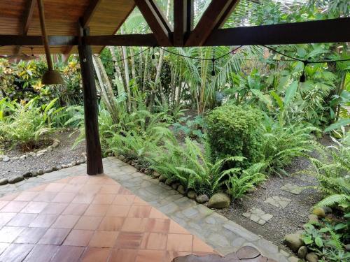 a garden with plants and a pavilion with a walkway at CasaMapache in Playa Hermosa