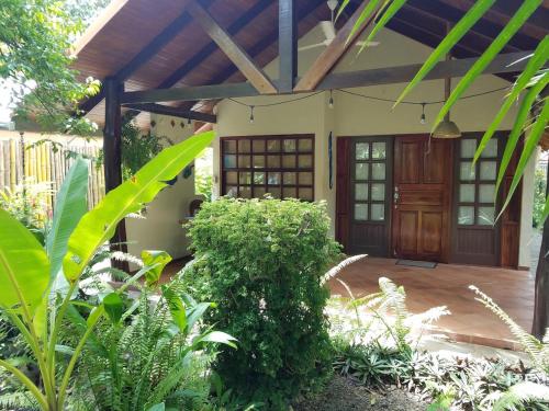 a house with a wooden door in a garden at CasaMapache in Playa Hermosa