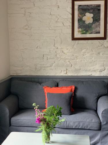 a gray couch with two orange pillows on it at Ardnagashel Estate No 4 in Ballylickey