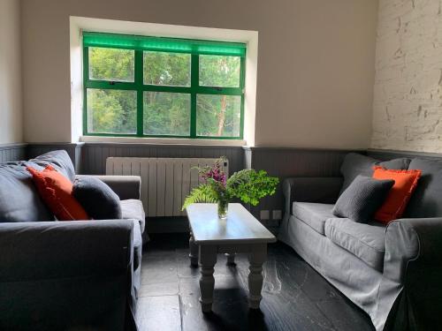 a living room with two couches and a table at Ardnagashel Estate No 4 in Ballylickey
