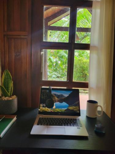 a laptop computer sitting on a desk in front of a window at CasaMapache in Playa Hermosa