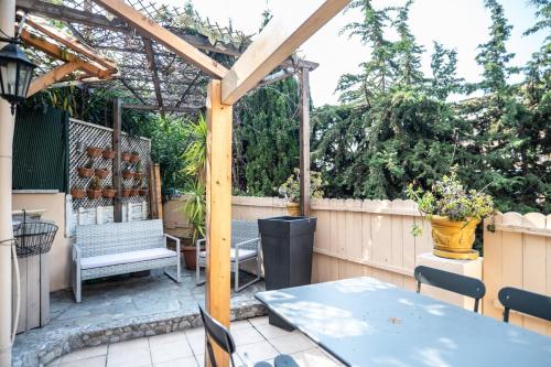 une terrasse avec une pergola, une table et des chaises dans l'établissement GuestReady - Enchanted stay with garden in Cimiez, à Nice