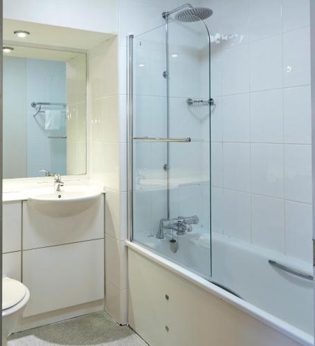 a bathroom with a glass shower and a sink at Craigside Manor in Llandudno