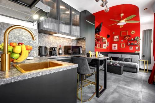 - une cuisine avec un évier et un mur rouge dans l'établissement TBS 328 - Lovely studio near Quartier Marais, à Paris