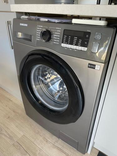 a washing machine with its door open in a kitchen at Villa Maria Southbourne - 2 Mins to Beach - Coastal - Dog-Friendly - Modern Luxury - Large Private Garden - Private Access - Parking in Southbourne