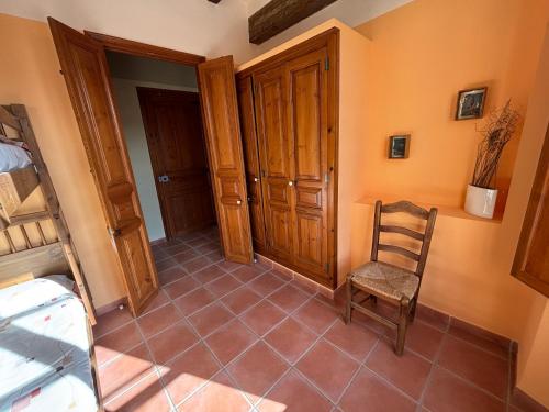 a room with a chair and a bedroom at Cal Capdevila in Pira