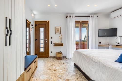 a bedroom with a large bed and a television at Villa Angelo in Paleokastritsa