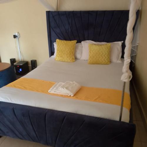 a large bed with yellow pillows in a room at Maureen Homes in Bomet