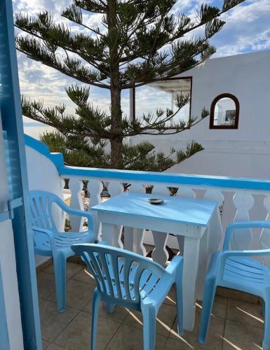 a table and chairs on a balcony with a tree at Stella Nomikou Apartments in Firostefani