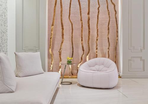 a living room with a white couch and a chair at Hotel Crescent Court in Dallas