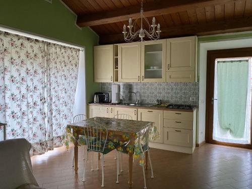 a kitchen with a table with chairs and a window at Agriturismo Vezzano in Chiusi della Verna