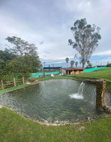 a pond with a fountain in a park at Finca Quinta el chalet in Calima