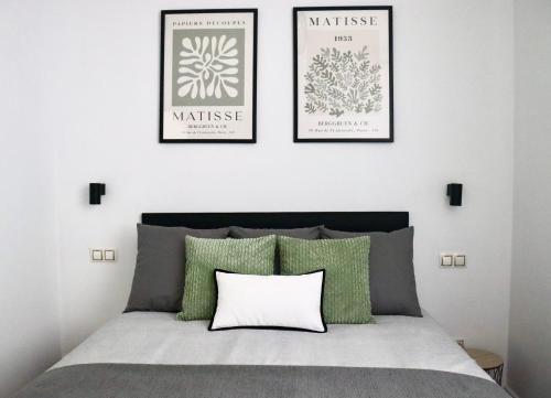 a bedroom with a bed with three pictures on the wall at La Biznaga Ávila in Avila