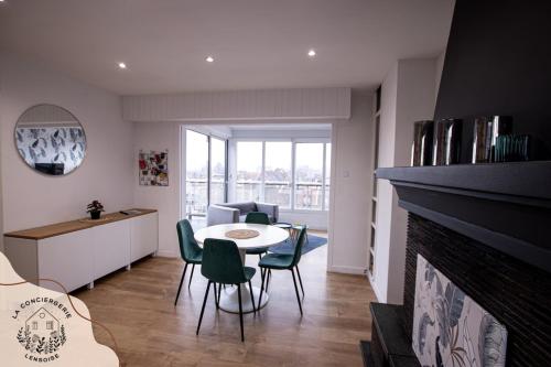 un salon avec une table et des chaises et une cheminée dans l'établissement Le Panoramic lensois, à Lens