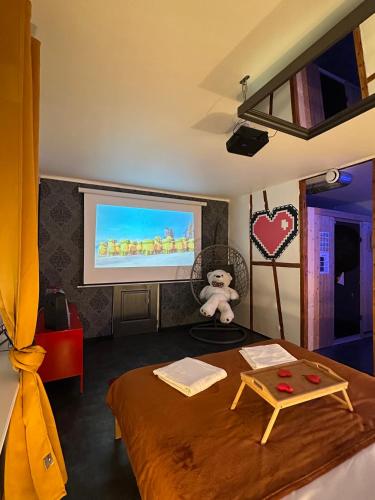 Cette chambre comprend un lit et un écran de projection. dans l'établissement Évasion Spa Jacuzzi Sauna, à Eckbolsheim
