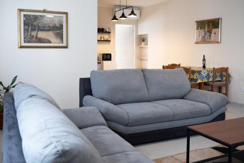 a living room with a blue couch and a table at Cetinale Apartments in Cavriglia