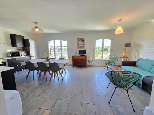 un salon avec un canapé, une table et des chaises dans l'établissement Goodlife - à 5 min à pieds de la mer avec balcon & parking - By AURAconciergerie, à Saint-Cyr-sur-Mer