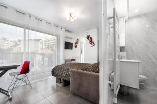 une chambre avec un lit, un bureau et une fenêtre dans l'établissement Charmant Studio - Calme - Croisette & Plage à 7 min, à Cannes