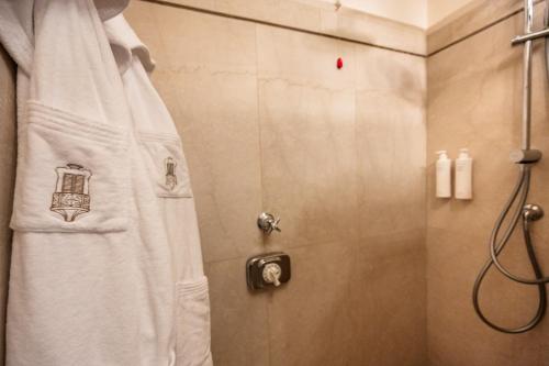 a shower with a white shower curtain in a bathroom at Palazzo Porta Picta in Bergamo